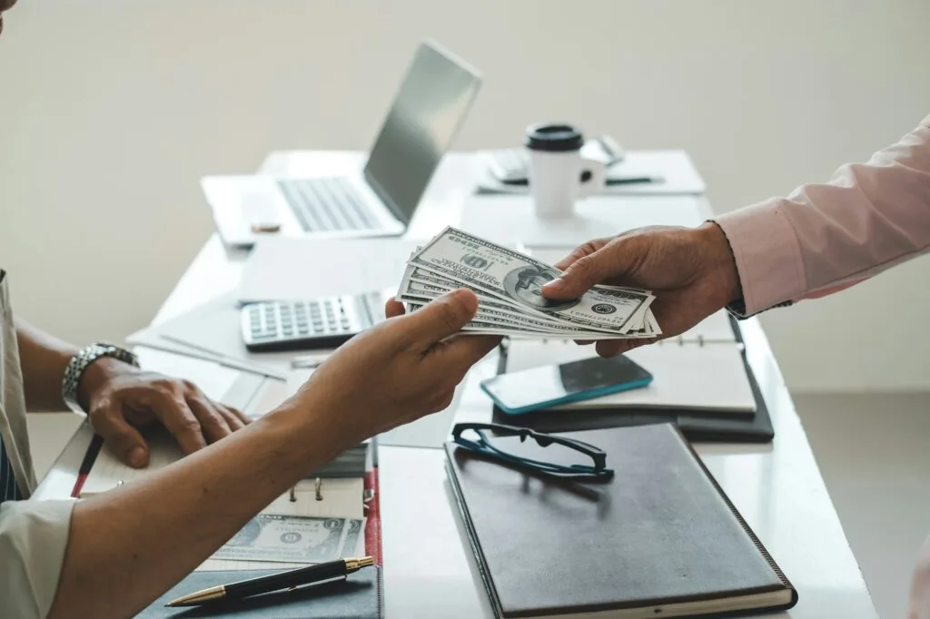 Businessman giving money to his partner. Bribe and corruption concept.